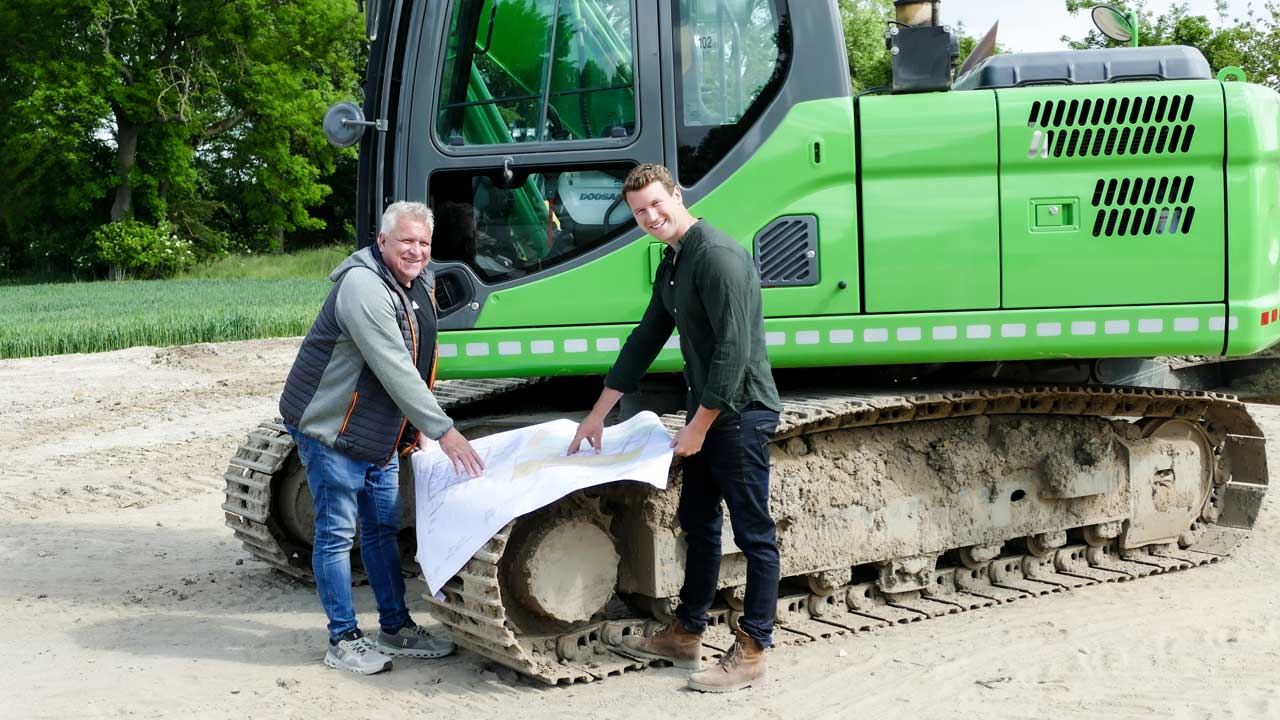 Martin und Marvin Wierbrügge vor einer Baumaschine